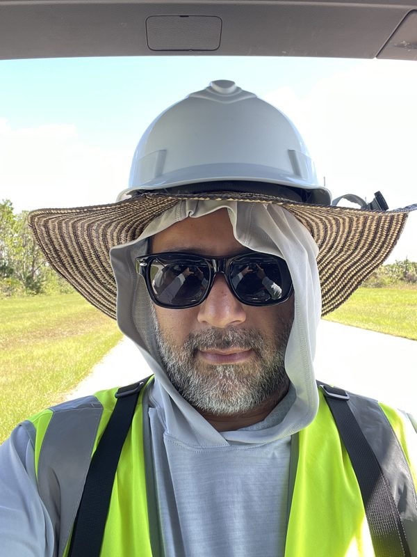 Sebastian on site in full PPE — hard hat, hi-vis vest, and sun protection
